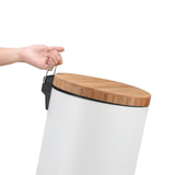 a hand holding a wooden lid on a white cylinder